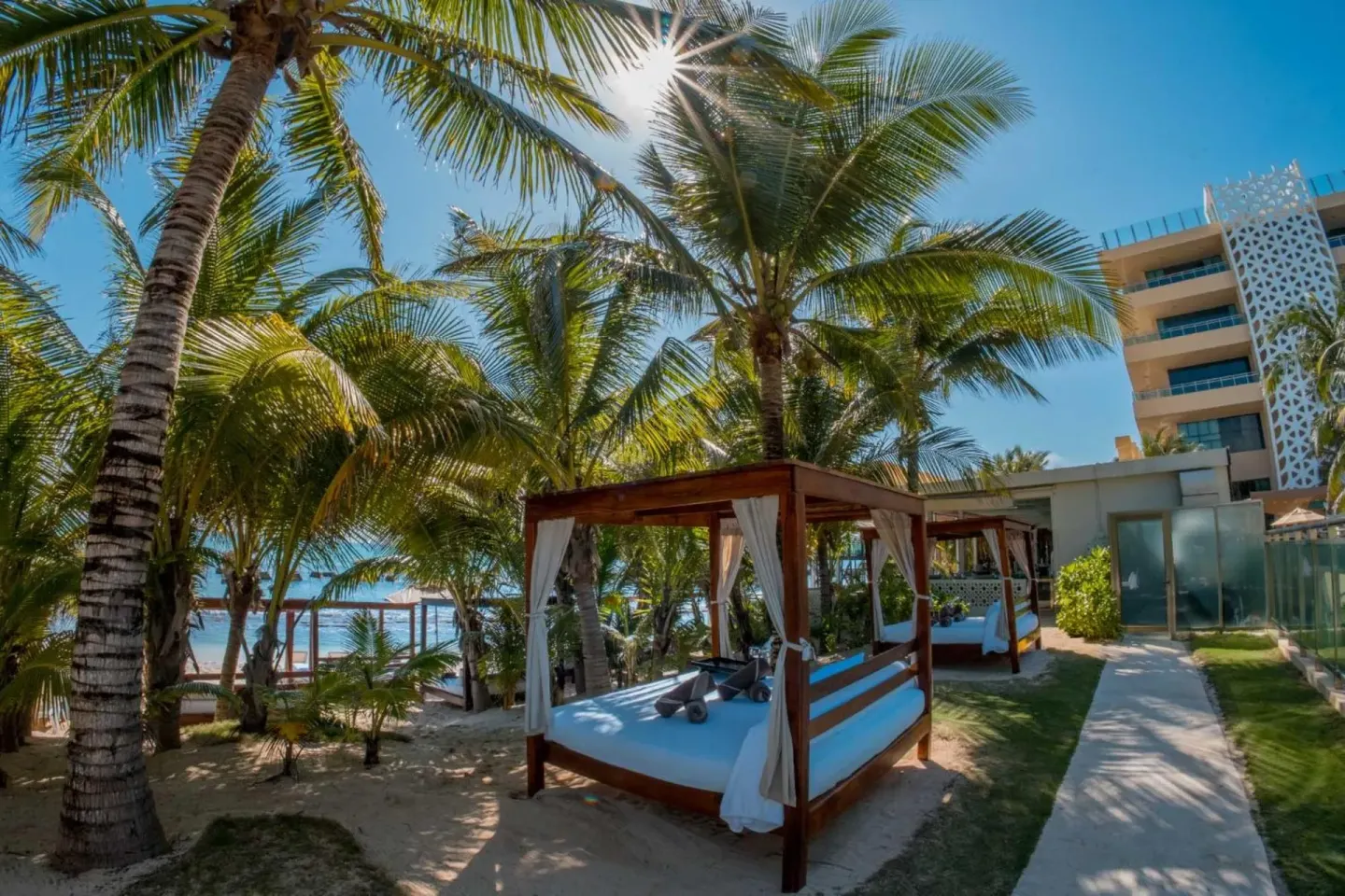Palm-shaded beach beds and a walkway at Generations Riviera Maya.