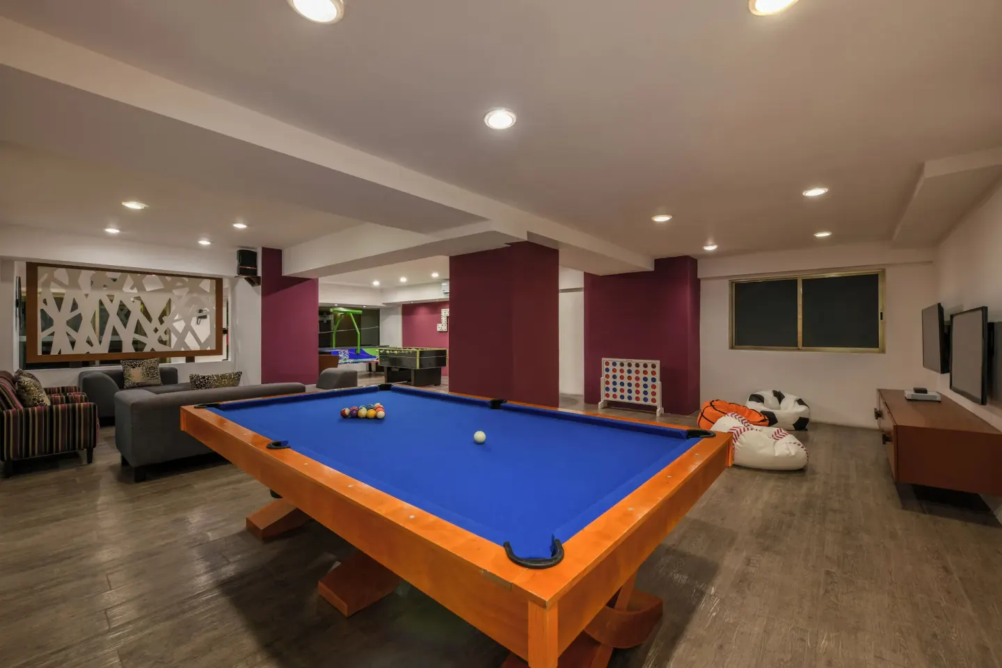 A recreation room with a blue pool table and lounge seating at Generations Riviera Maya.