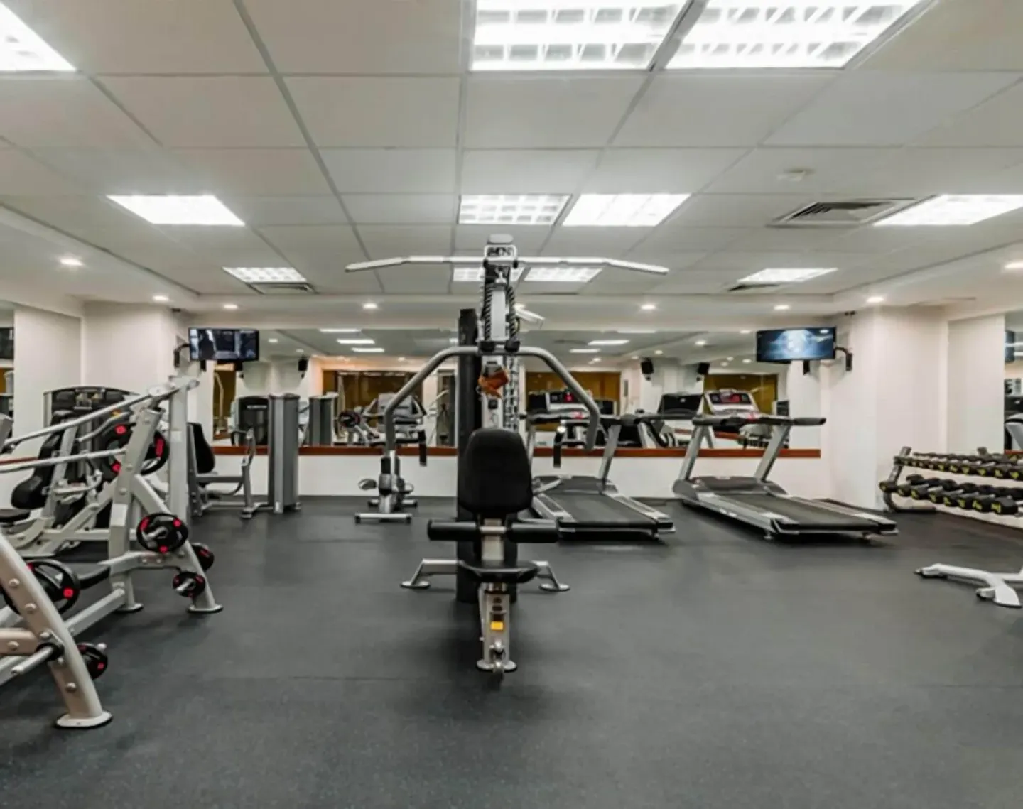Fitness room with treadmills, weights, and exercise machines at GR Solaris Cancun & Spa.