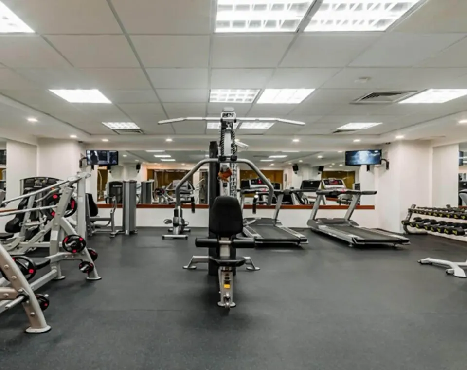 Fitness room with treadmills, weights, and exercise machines at GR Solaris Cancun & Spa.