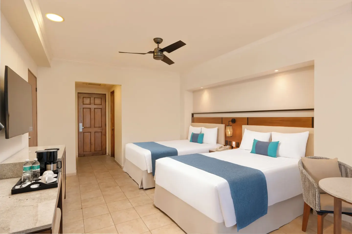 Two double beds in a guest room with TV and coffee counter at GR Solaris Cancun & Spa.