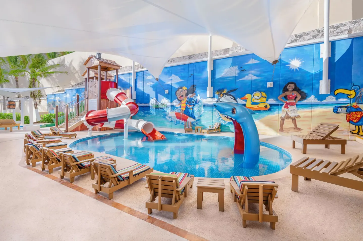 Kids’ pool with red-and-white slide and dolphin sprayer at GR Solaris Cancun & Spa.