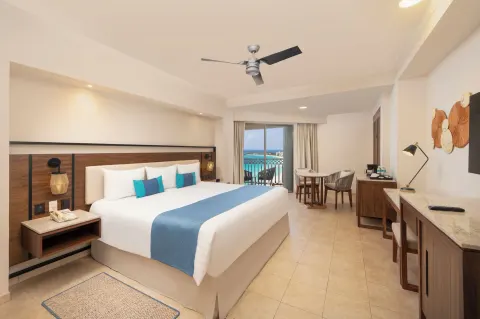 King guest room with desk, seating area, and ocean balcony at GR Solaris Cancun & Spa.