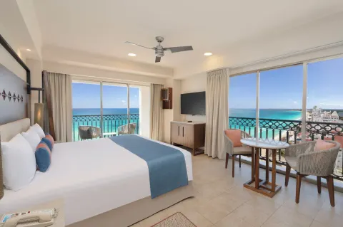 King bed guest room with ocean-facing windows at GR Solaris Cancun & Spa.