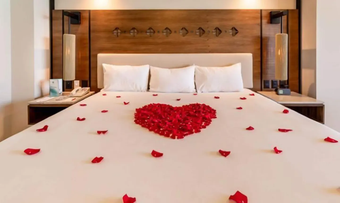 King bed decorated with red rose petals at GR Solaris Cancun & Spa.