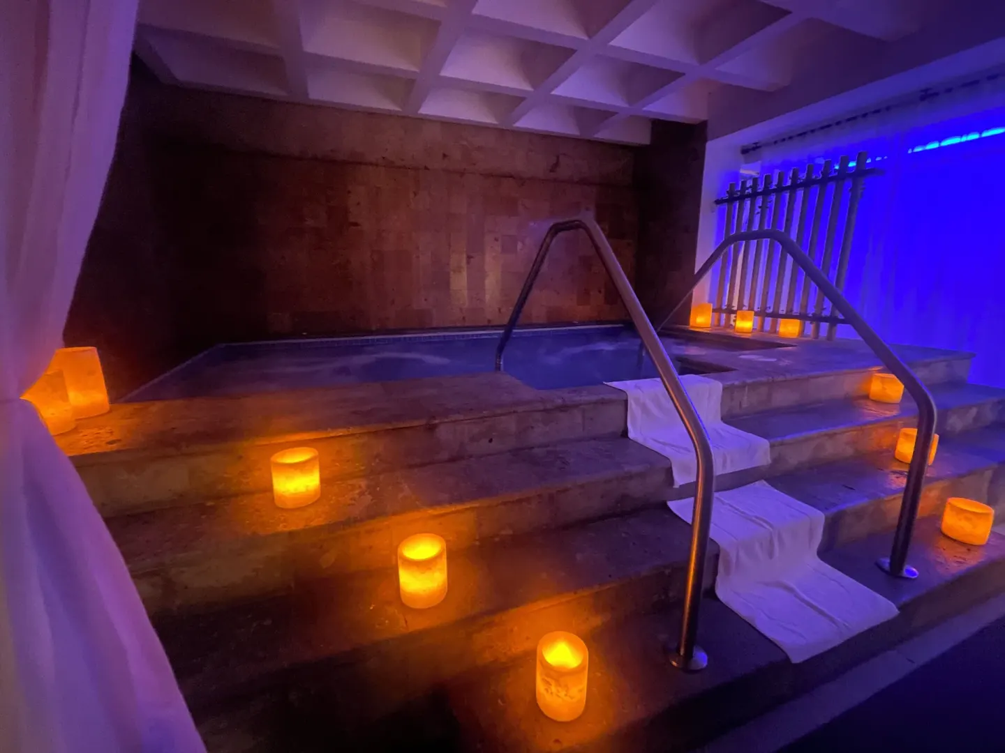 Spa hydrotherapy pool with candles and blue lighting at GR Solaris Cancun & Spa.