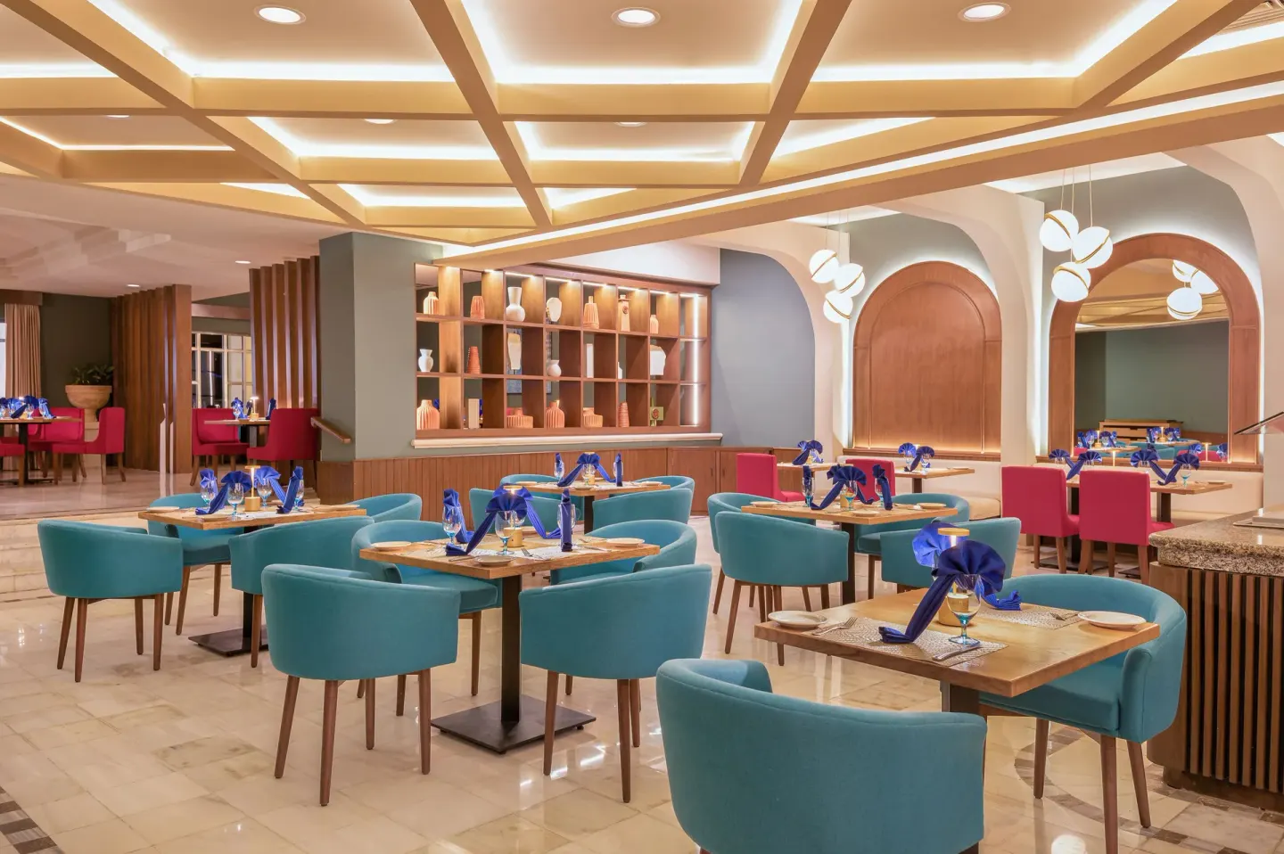 Restaurant dining room with teal chairs and blue napkins at GR Solaris Cancun & Spa.