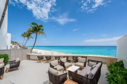 Outdoor terrace seating overlooking the beach and turquoise water at GR Solaris Caribe.