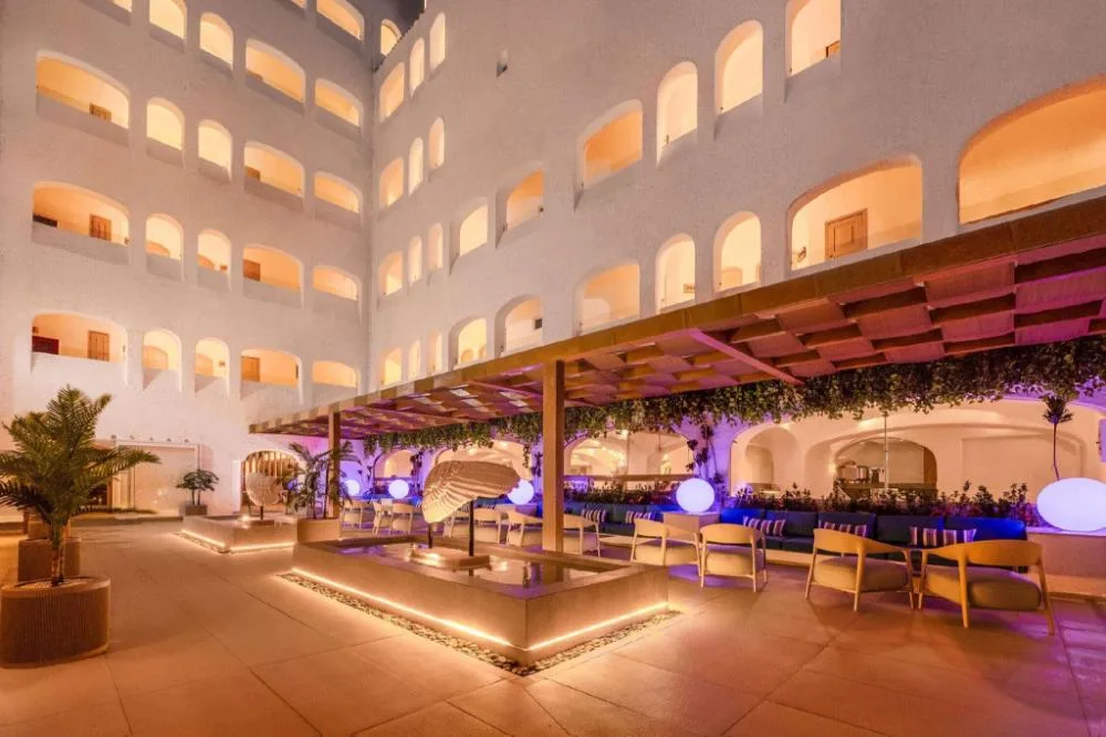 Evening courtyard with lounge seating and illuminated arches at GR Solaris Caribe.