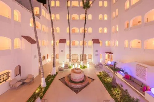 Illuminated courtyard with palms and fountain at GR Solaris Caribe.
