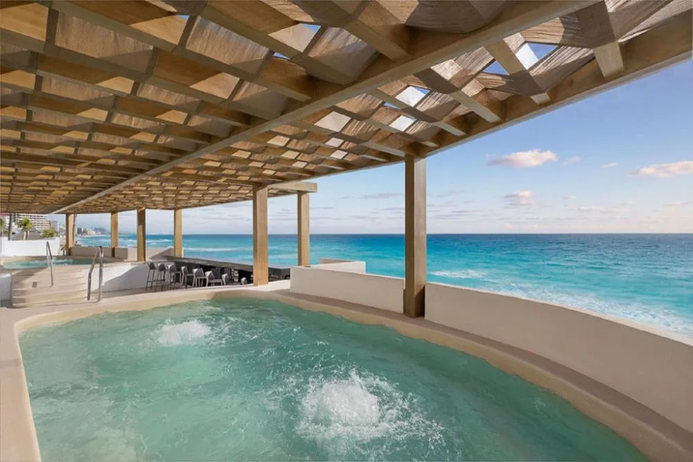 Oceanfront whirlpool under a shaded pergola at GR Solaris Caribe.