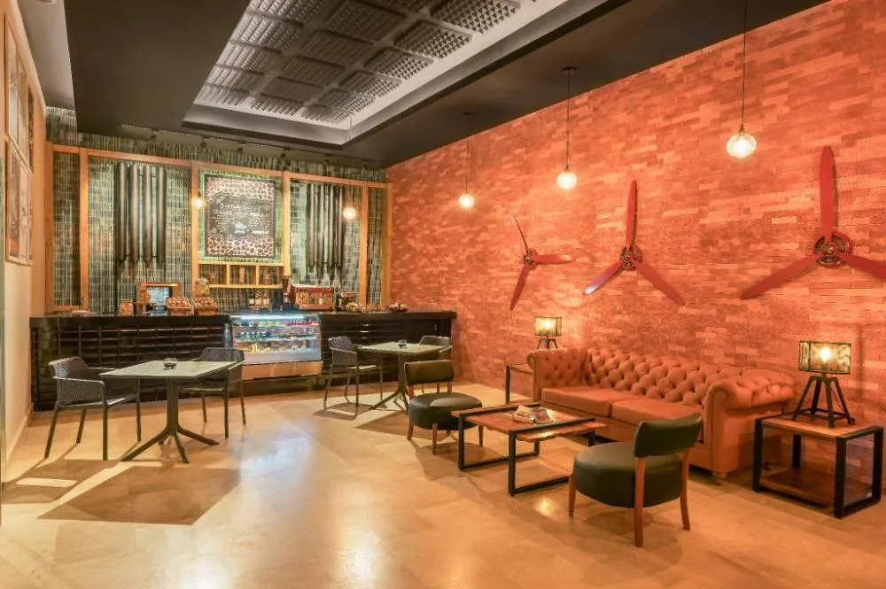 Modern café lounge with display case and orange brick wall at GR Solaris Caribe.