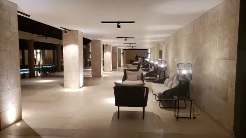 Covered lobby lounge corridor with armchairs and lamps at Grand Bavaro Princess.