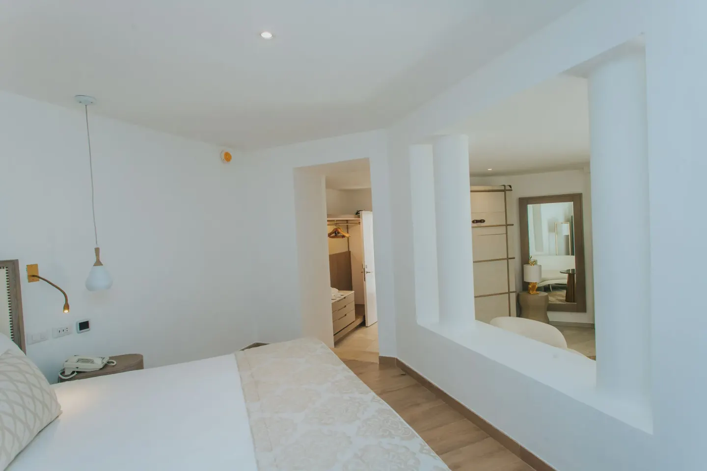 Guest room bed beside an open dressing area at Grand Bavaro Princess.
