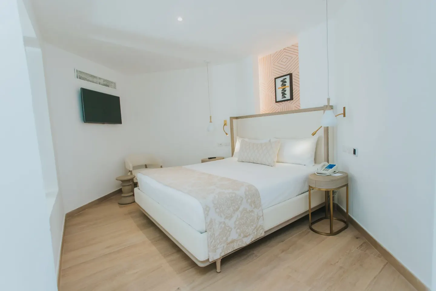 King bed with wall-mounted TV and bedside tables at Grand Bavaro Princess.