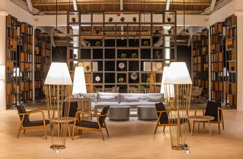 Modern lobby lounge with sofas, lamps, and open shelving at Grand Bavaro Princess.