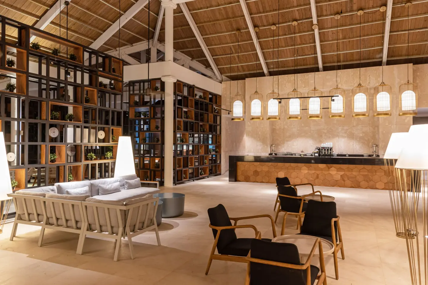 Lobby lounge with sofas, chairs, shelving, and a service counter at Grand Bavaro Princess.