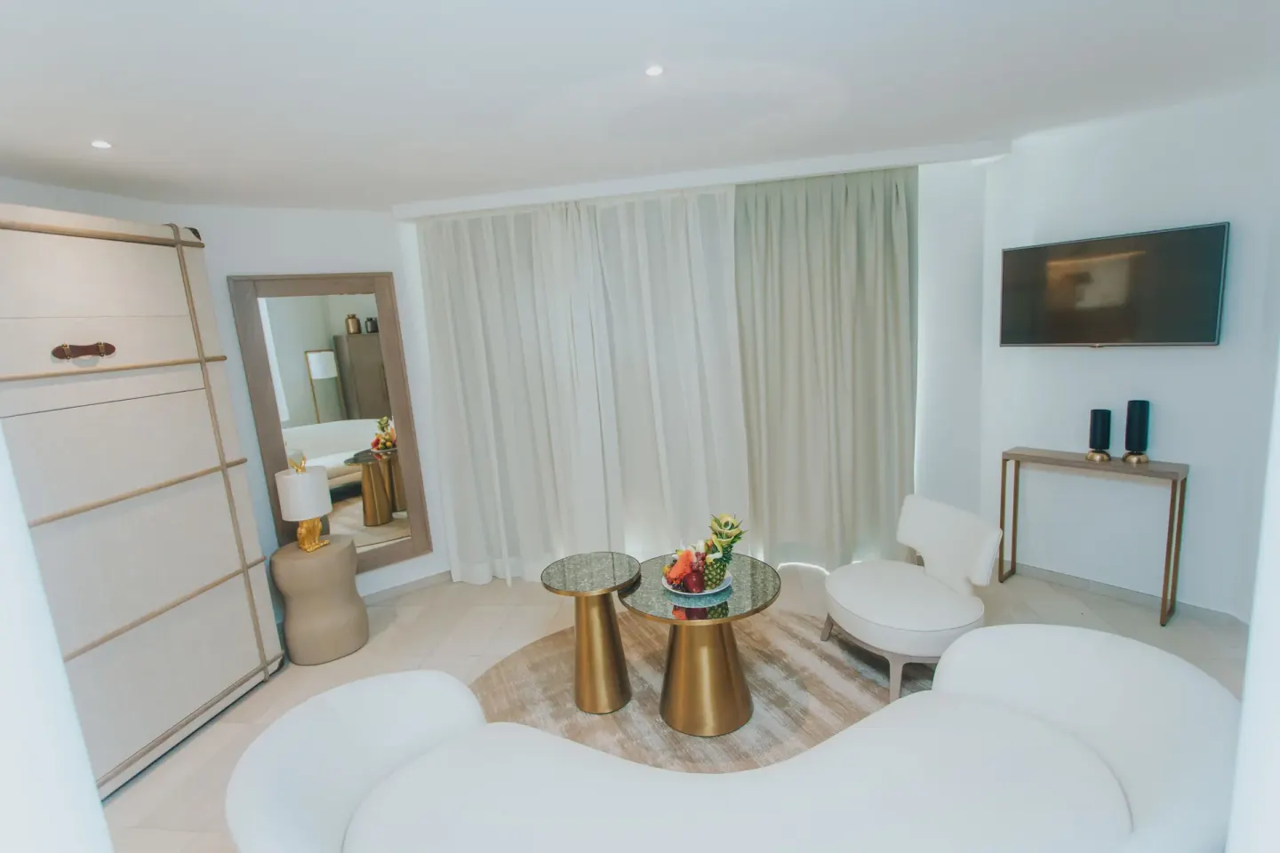 White lounge seating with glass tables in a suite living area at Grand Bavaro Princess.