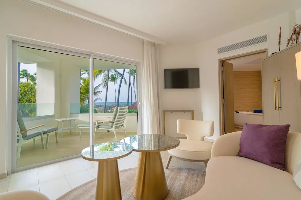 Suite sitting area with glass balcony doors at Grand Bavaro Princess.