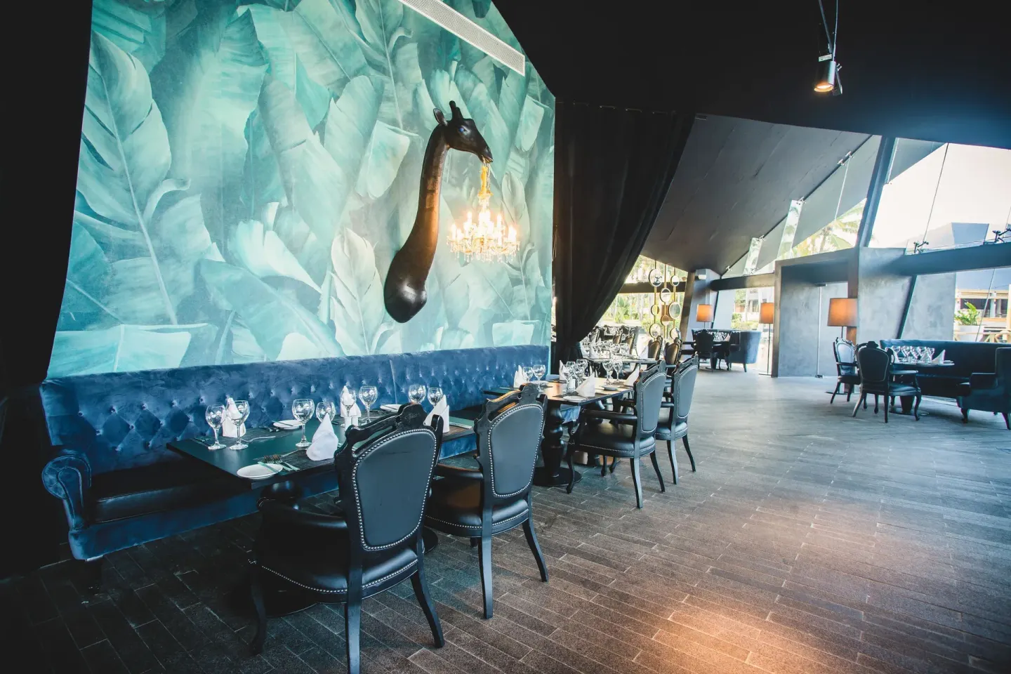 Dramatic dining room with blue banquette and leaf mural at Grand Bavaro Princess.