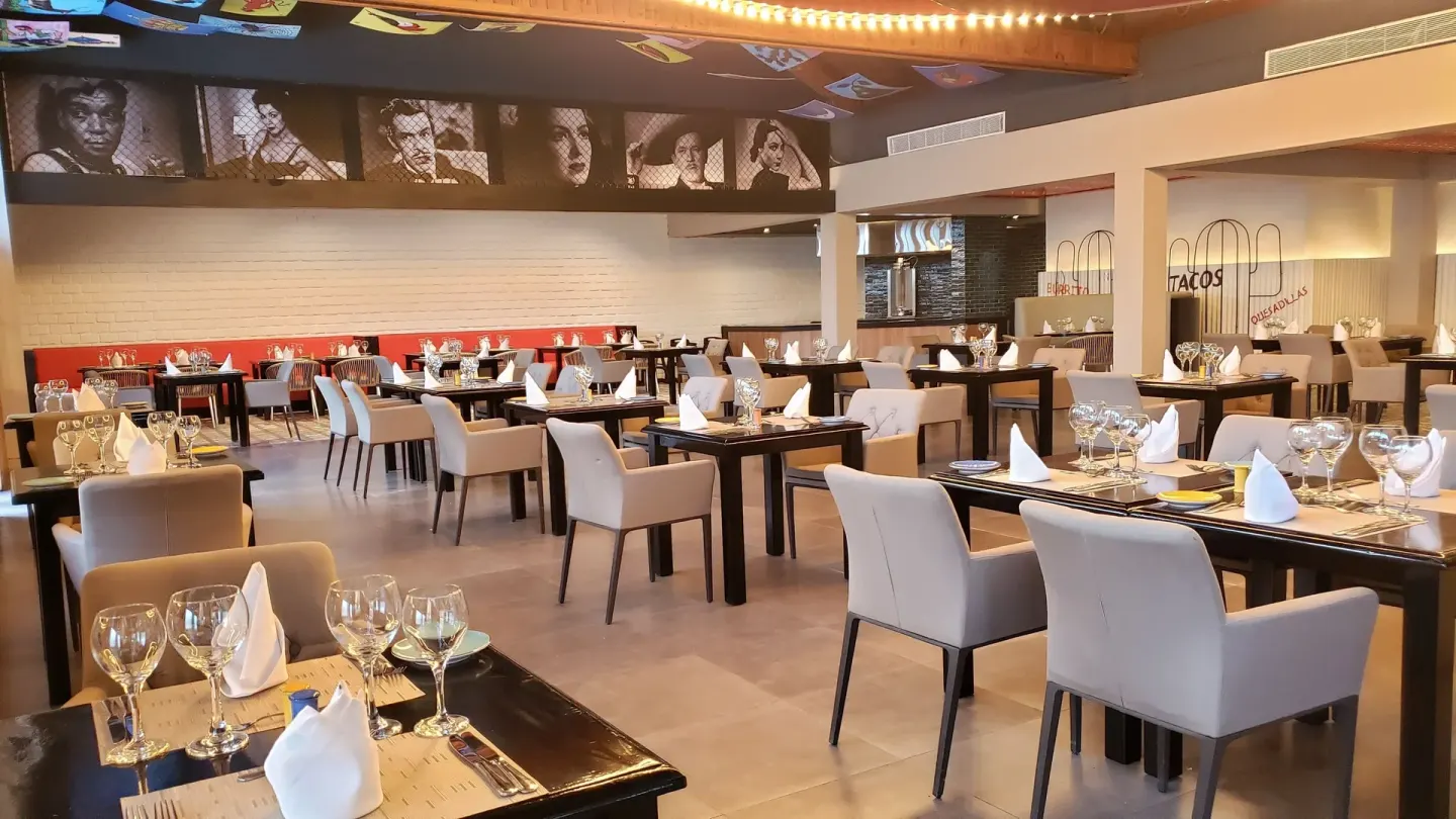 Mexican-themed restaurant interior with portraits and set tables at Grand Bavaro Princess.