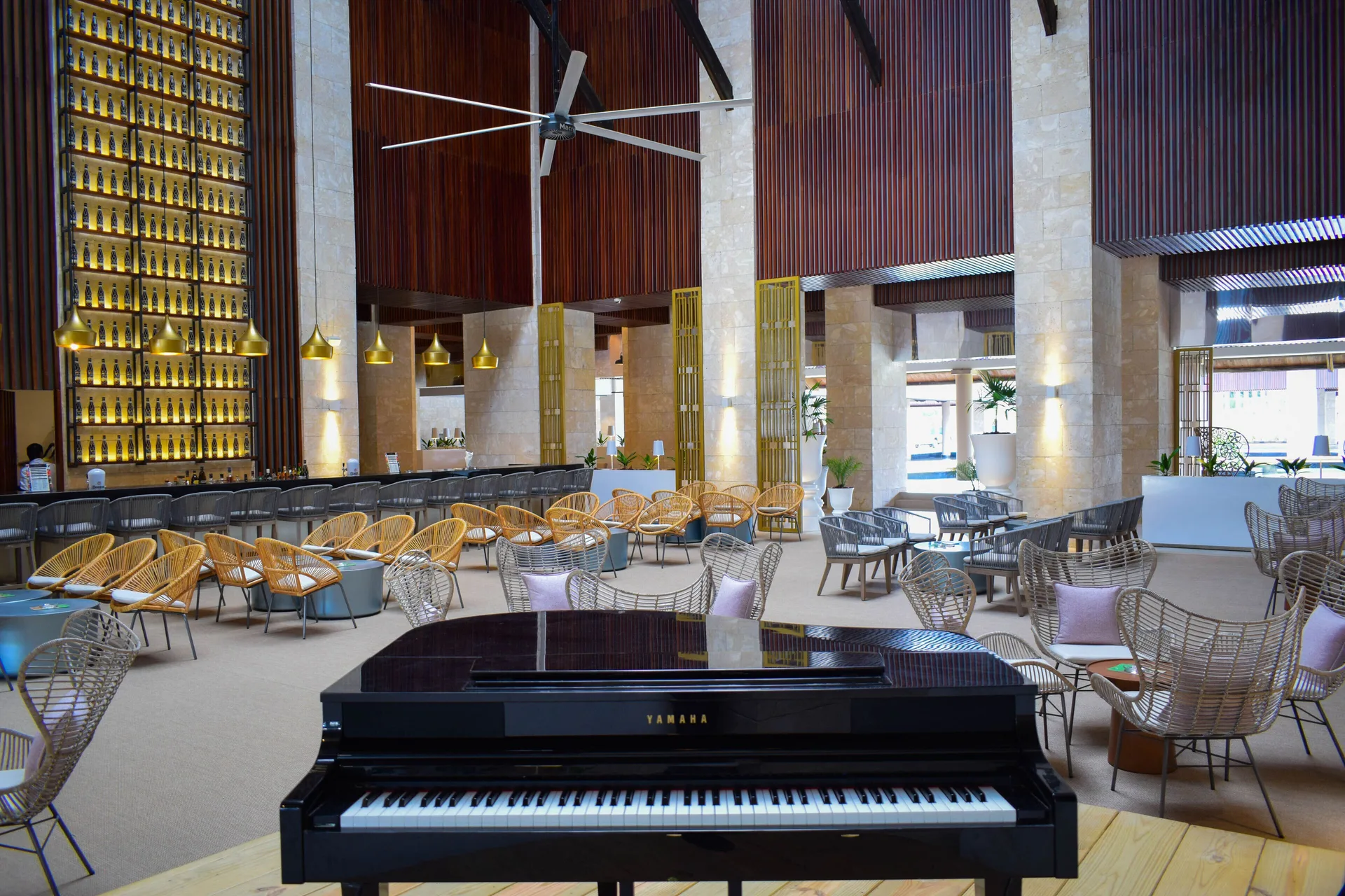 Lobby bar lounge with grand piano and wicker seating at Grand Bavaro Princess.