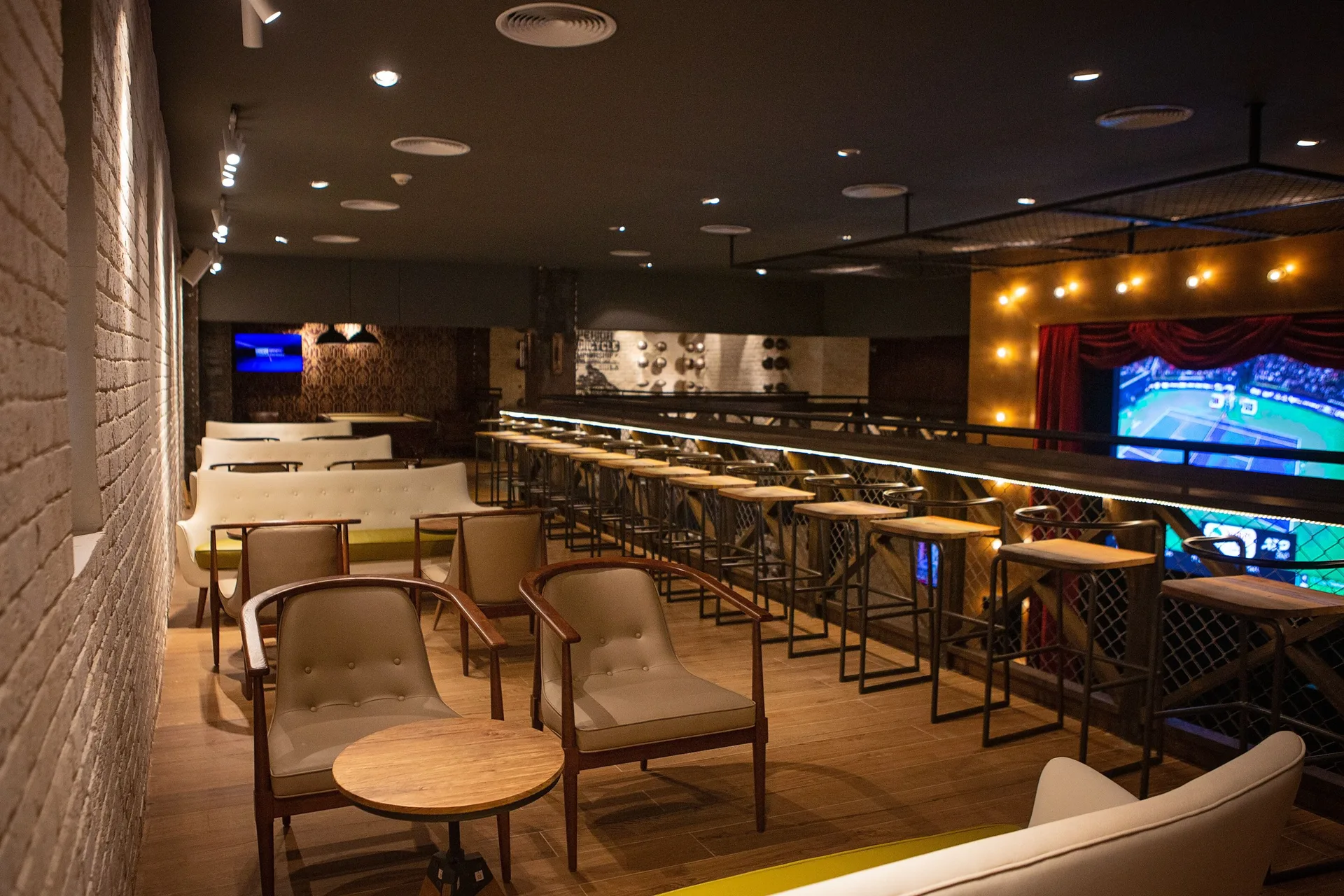 Sports bar lounge with stadium seating and large screens at Grand Bavaro Princess.