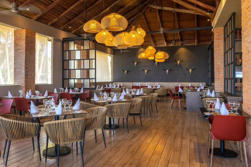 Rustic restaurant dining room with woven chairs at Grand Bavaro Princess.
