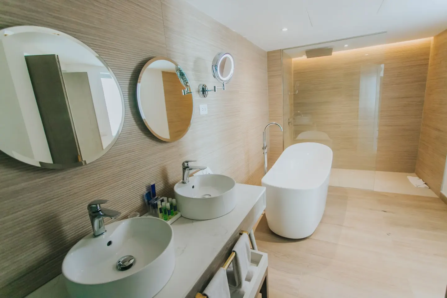 Bungalow bathroom with double sinks, freestanding tub, and glass shower at Grand Bavaro Princess.