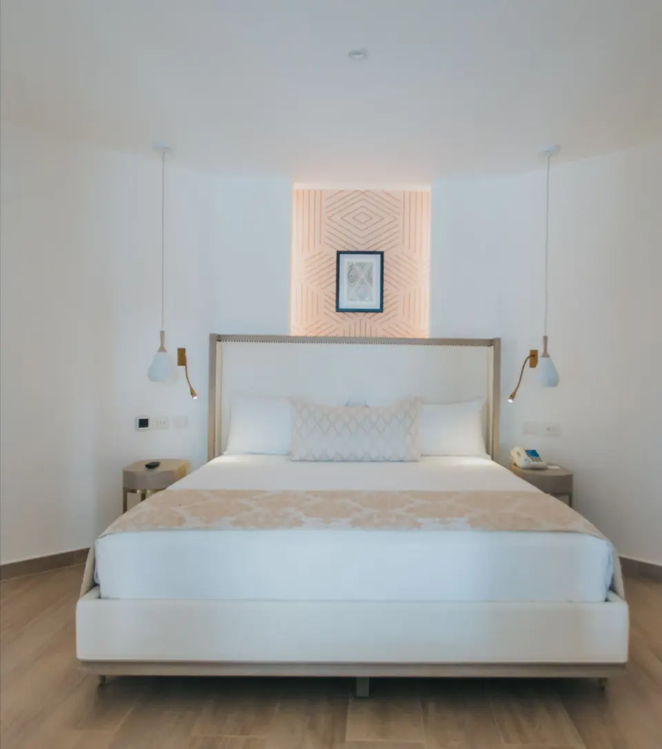 Front view of bungalow king bed with hanging lamps at Grand Bavaro Princess.