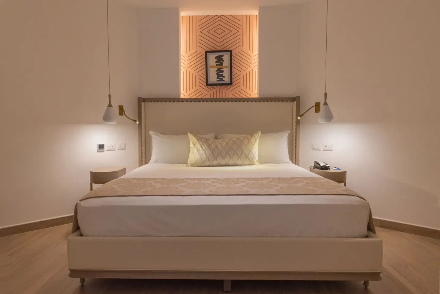 Evening view of bungalow king bed with warm bedside lighting at Grand Bavaro Princess.