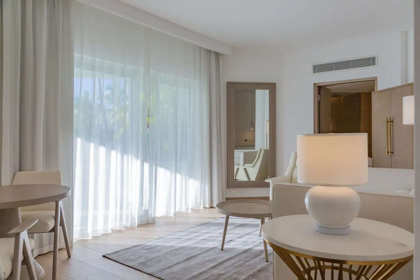 Bungalow sitting area with sheer curtains and a table at Grand Bavaro Princess.
