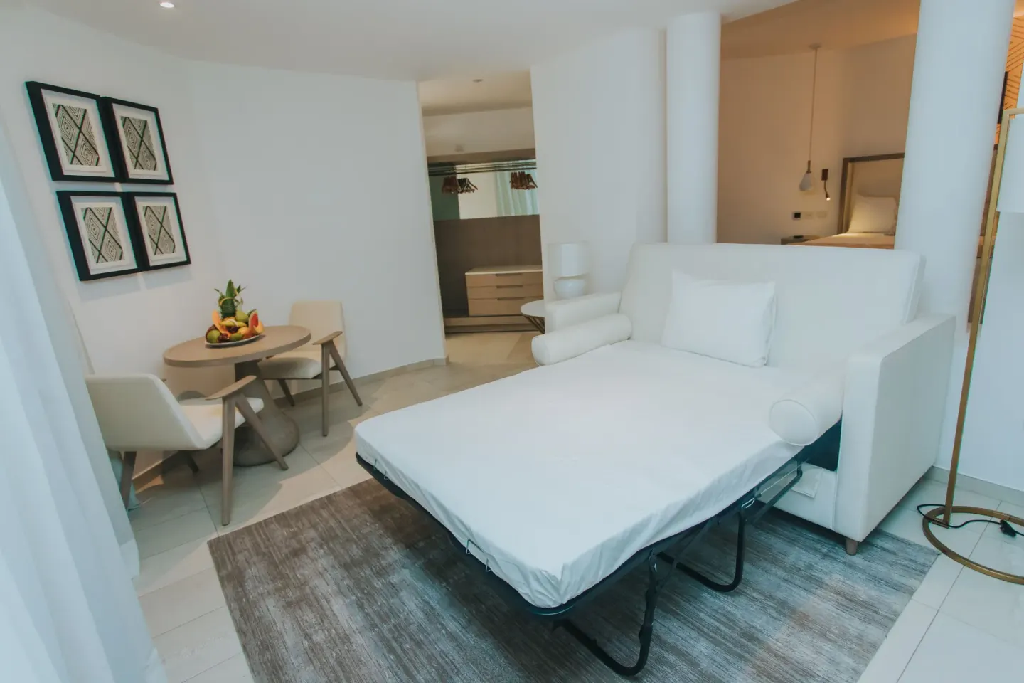 Bungalow sitting area with sofa bed and dining table at Grand Bavaro Princess.