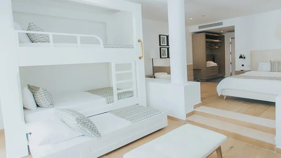 Triple bunk beds beside the king bed in the Family Club Junior Suite at Grand Bavaro Princess.