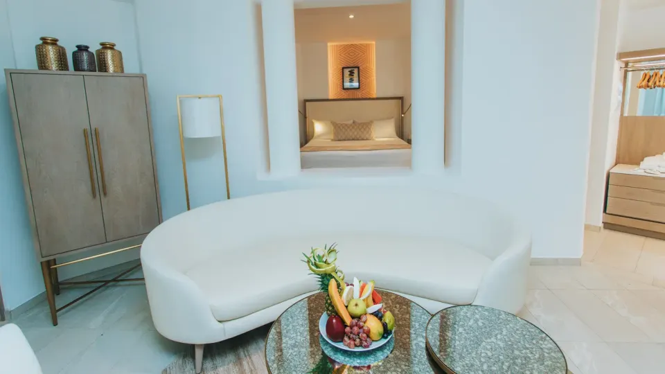 Platinum Suite living room with curved sofa opening to the king bedroom at Grand Bavaro Princess.