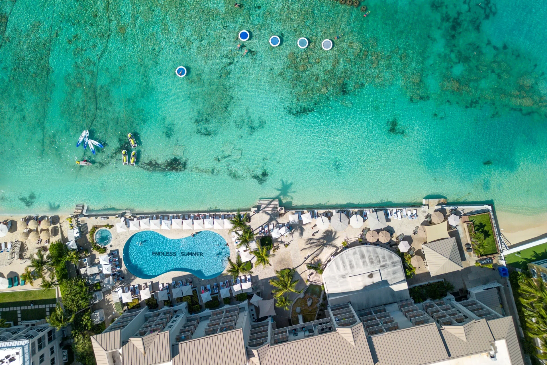 Aerial view of the beachfront pool and turquoise water at Grand Cayman Marriott Resort.