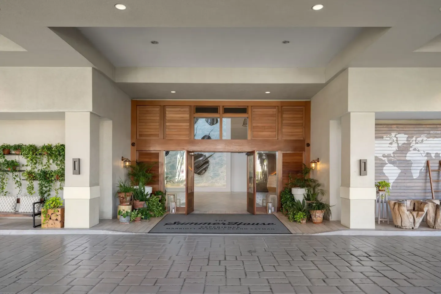 Covered resort entrance with wood doors and potted plants at Grand Cayman Marriott Resort.