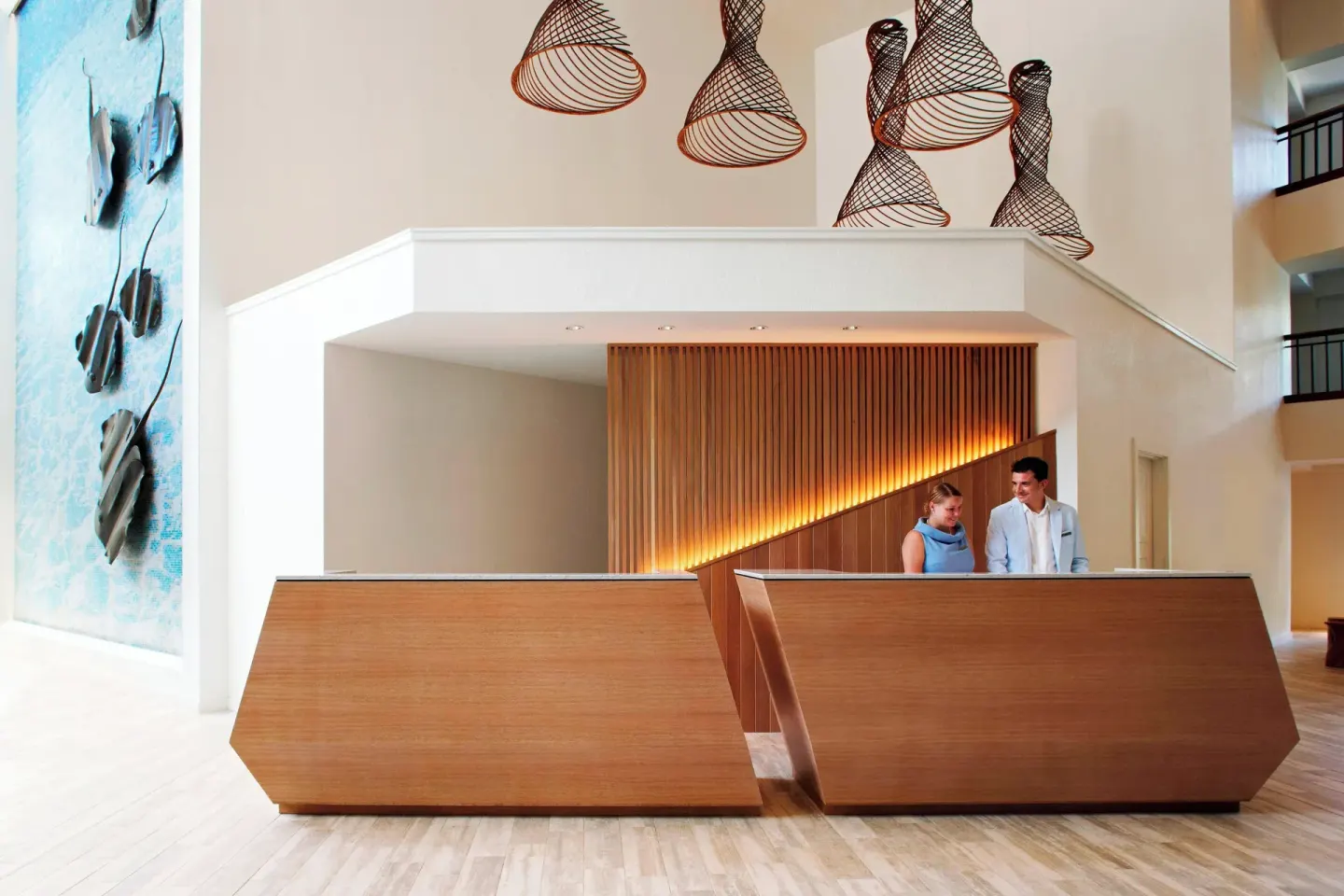 Front desk with wood counters and woven ceiling decor at Grand Cayman Marriott Resort.
