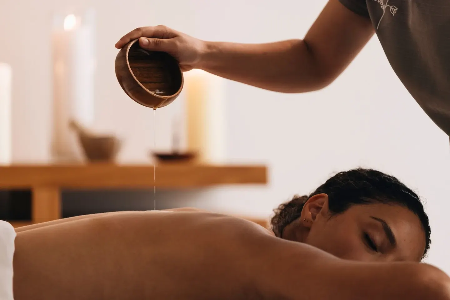 Therapist pours oil during a massage treatment at Grand Cayman Marriott Resort.
