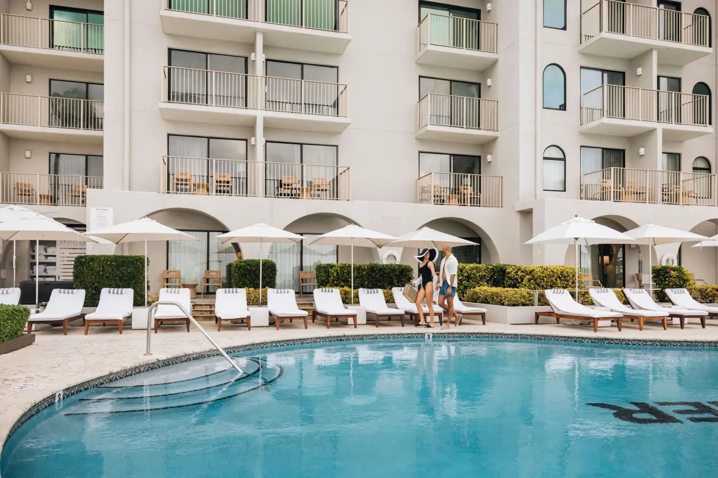 Pool deck with loungers and guest balconies at Grand Cayman Marriott Resort.