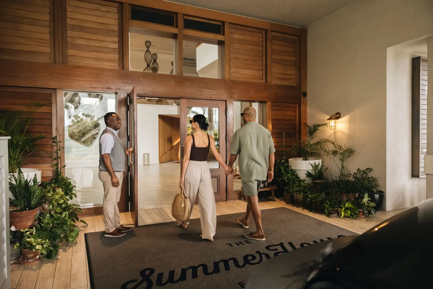 Guests arriving at the wood-framed entrance of Grand Cayman Marriott Resort.