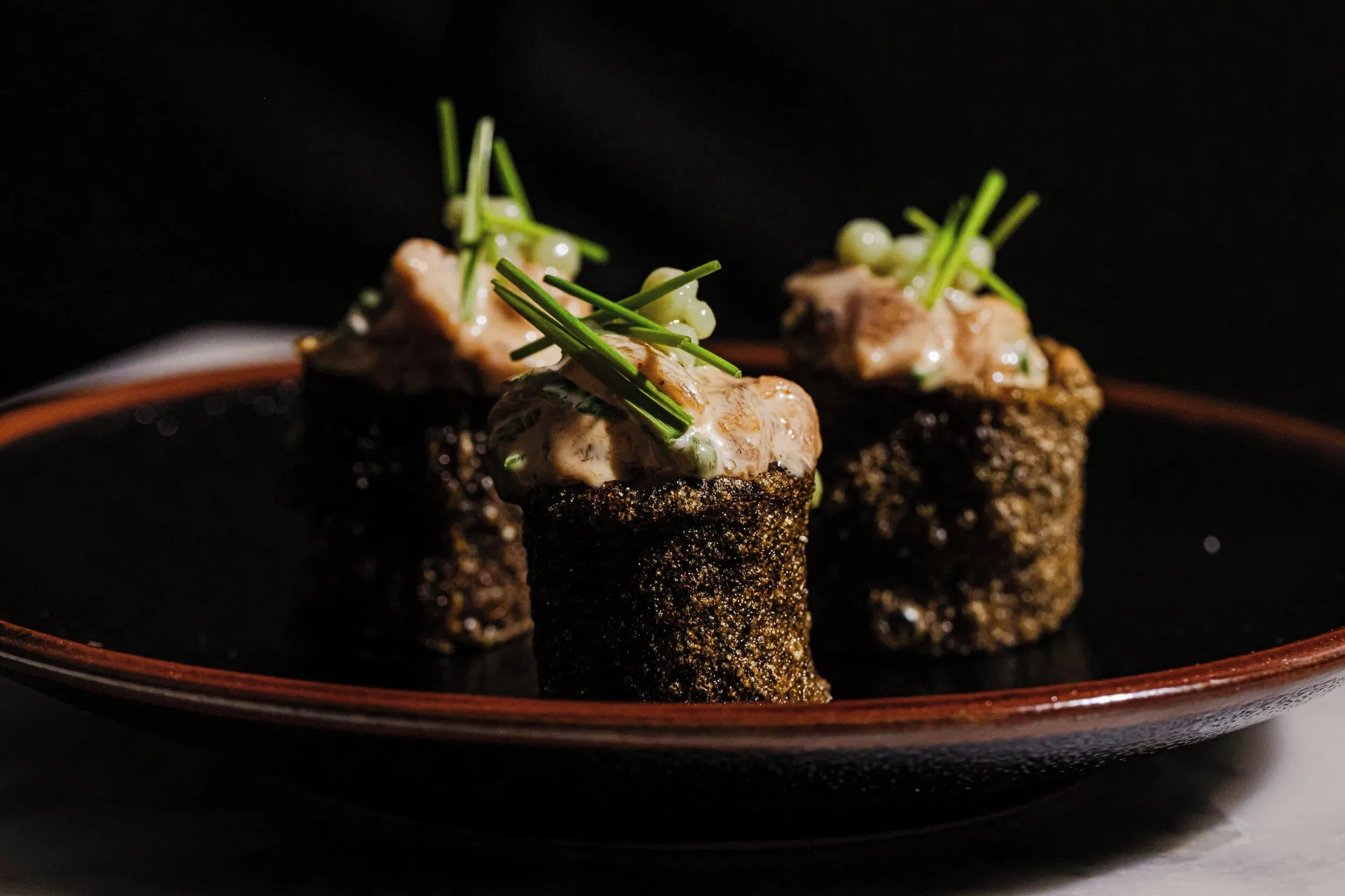 Sushi-style bites on a dark plate at Grand Cayman Marriott Resort.