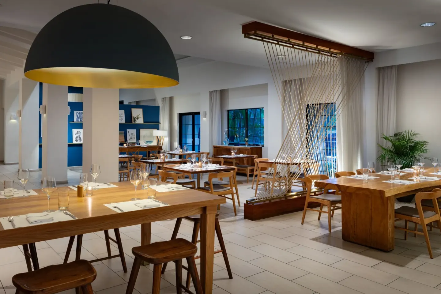 Dining room with wood tables and modern lighting at Grand Cayman Marriott Resort.