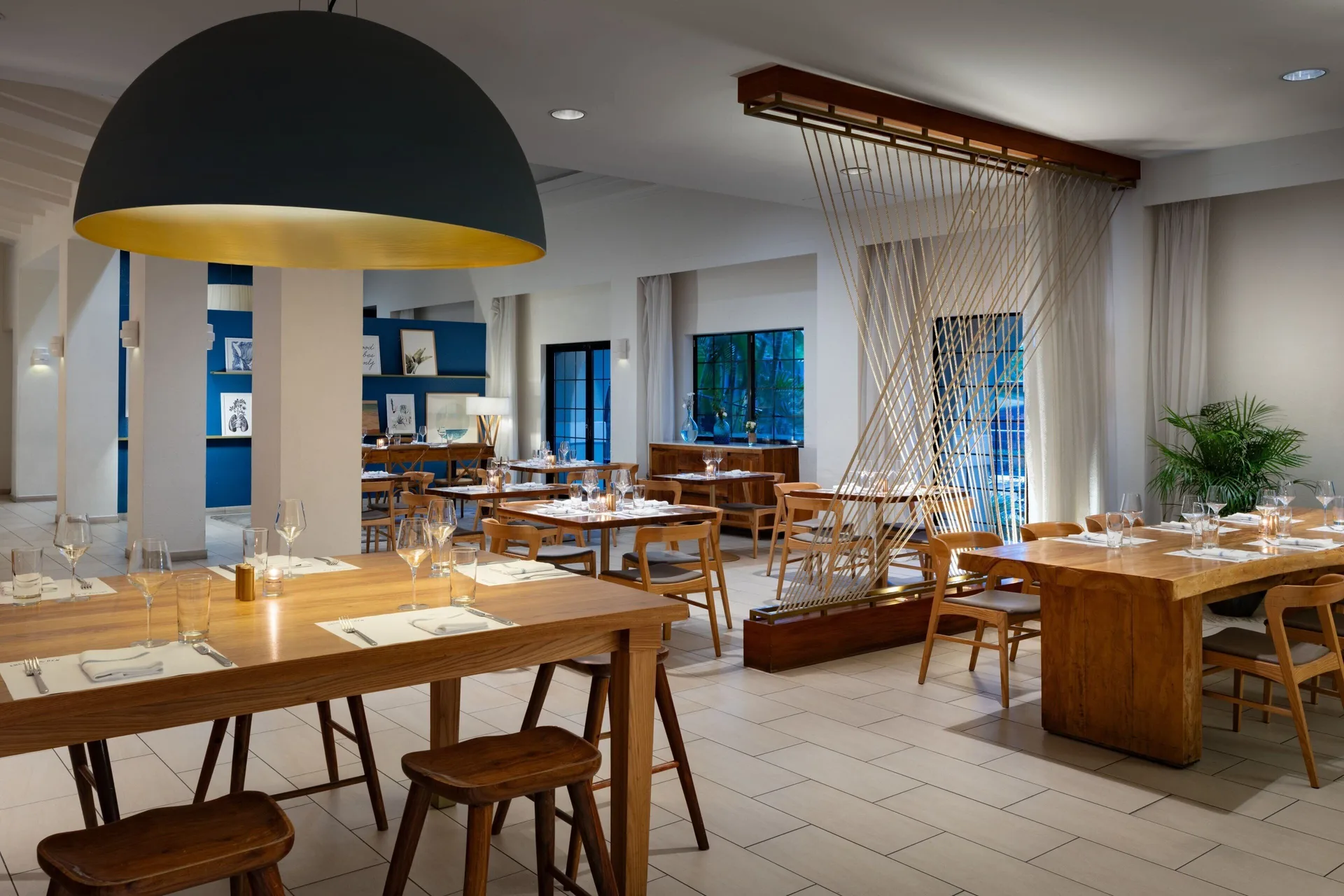 Dining room with wood tables and modern lighting at Grand Cayman Marriott Resort.