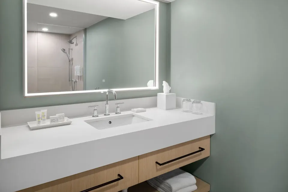 Grand Room oceanfront bathroom vanity and illuminated mirror at Grand Cayman Marriott Resort.