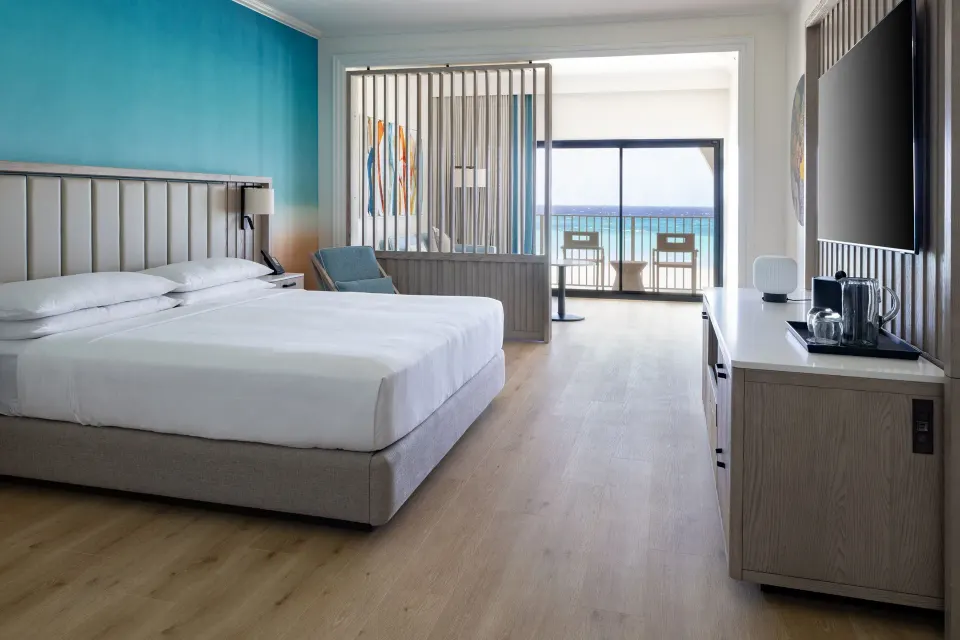 Junior suite king bed and balcony view at Grand Cayman Marriott Resort.