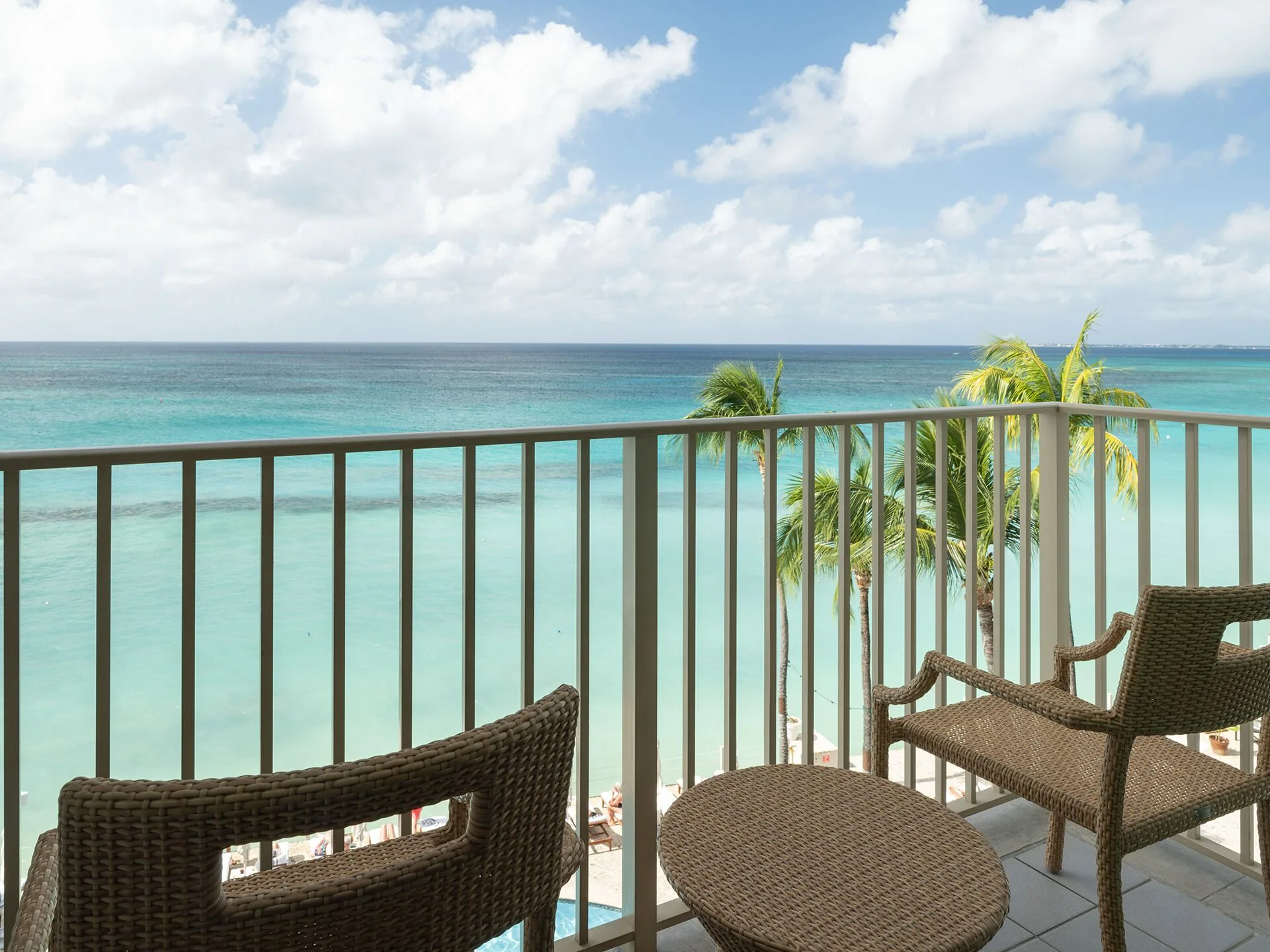 Oceanfront balcony with wicker seating and Caribbean Sea views at Grand Cayman Marriott Resort.