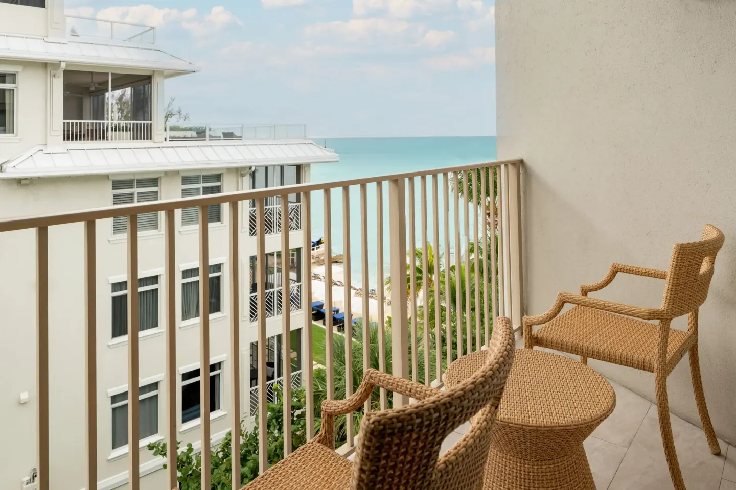 Balcony chairs and table with beach and ocean beyond at Grand Cayman Marriott Resort.