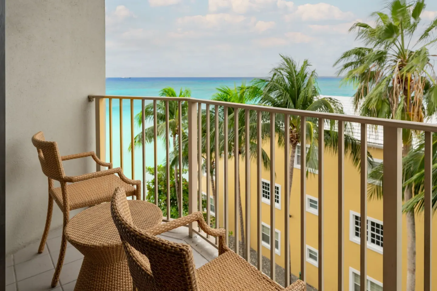 Balcony seating with palm trees and ocean view at Grand Cayman Marriott Resort.