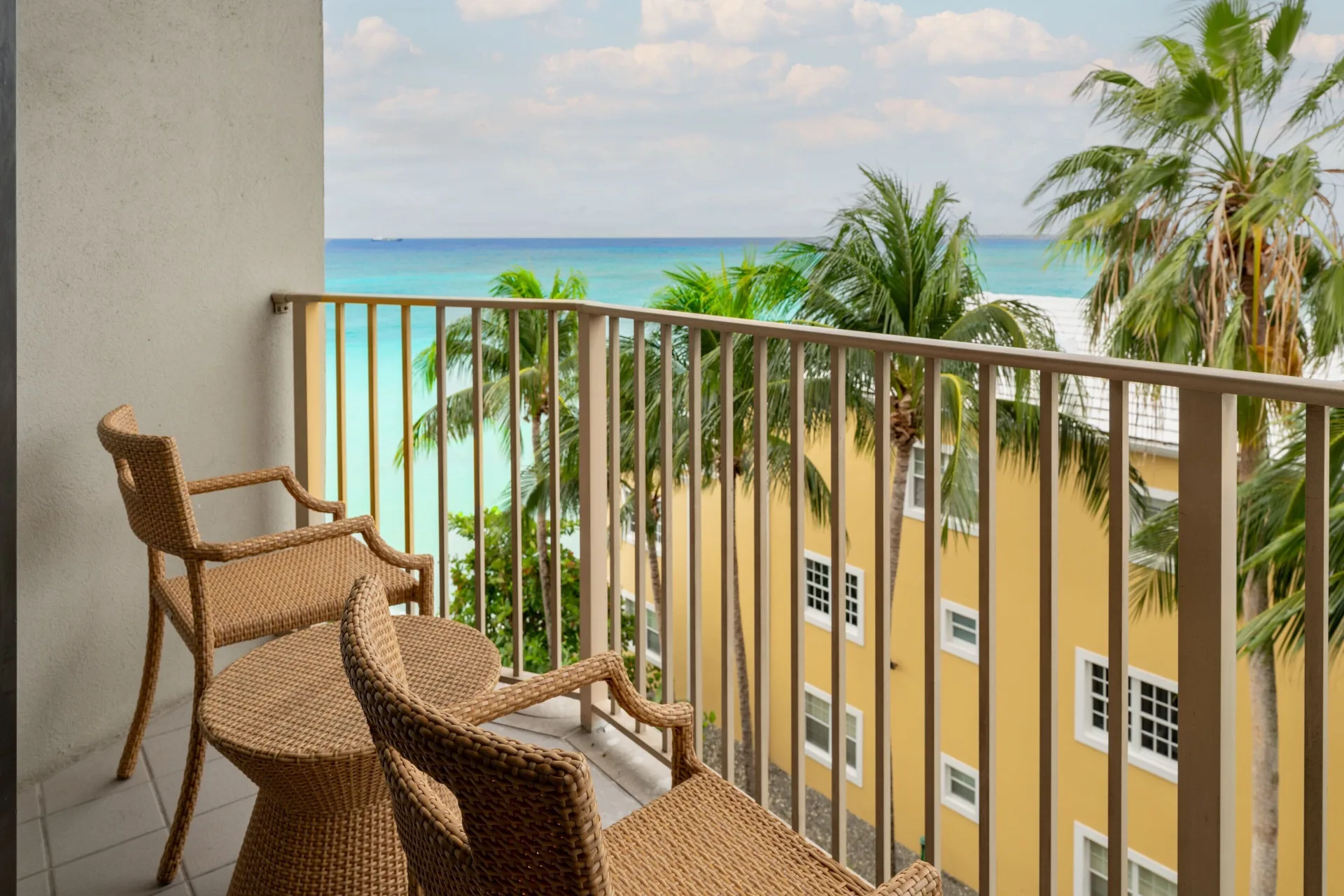 Balcony seating with palm trees and ocean view at Grand Cayman Marriott Resort.